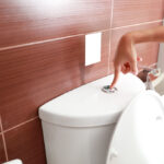 woman hand flush toilet after using