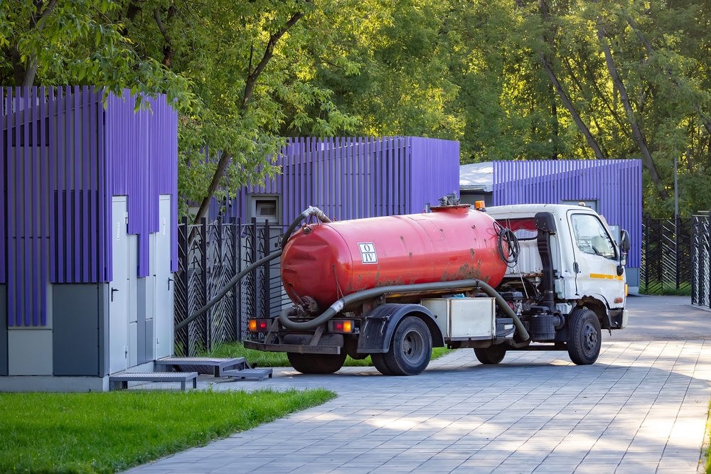 A clean concrete driveways with professional plumbing service truck parked nearby