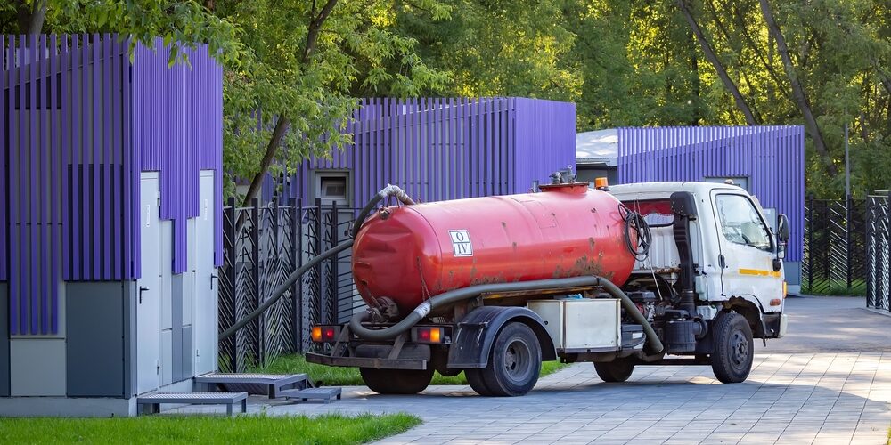 A clean concrete driveways with professional plumbing service truck parked nearby